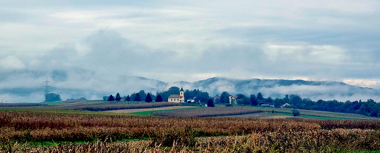 polje sa crkvom u daljini